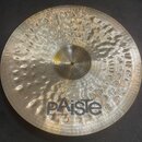 Zlatý kovový činel s výrazným kovaným povrchem a koncentrickými drážkami. V dolní části je černé logo Paiste a nápis MADE IN SWITZERLAND. V horní čás…