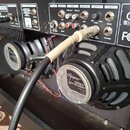 Zadní panel černého kytarového komba značky BEHRINGER s viditelnými konektory, ovládacím prvkem LEVEL a nápisy jako LINE OUT, AUX IN či INSERT. V pra…