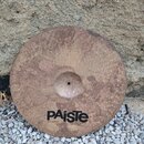 Kruhový činel z bronzu s viditelným kovánívým povrchem. V dolní části je černý nápis PAiSte a pod ním menší text MADE IN SWITZERLAND. Povrch je nepat…