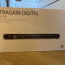 Kartonová krabice s nápisy ULTRAGAIN DIGITAL, ADA8200 a Audiophile 8 In/8 Out ADAT Audio Interface with MIDAS Mic Preamplifiers. V otvoru krabice je…