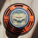 Kytarový reproduktor s oranžovým kovovým rámem a černým vnějším prstencem. Na středovém štítku je nápis WAREHOUSE GUITAR SPEAKERS, AMERICAN VINTAGE,…