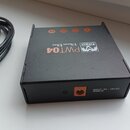 Černý napájecí adaptér s nápisem Palmer Power Bar PWT04 a logem znázornujícím dvě hory. Na zadní straně je vstup pro napájení s nápisem INPUT, 9V - 1…