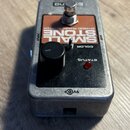 Kytarový efekt v kovovém stříbrném šasi s černým ovládacím panelem. Na oranžovém štítku je nápis SMALL STONE a pod ním EH4B00 PHASE SHIFTER. Přístroj…