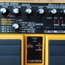 Žlutý kytarový efekt pedál s černým ovládacím panelem. Na panelu jsou nápisy OD-20 OVERDRIVE/DISTORTION, COSM a Drive Zone. Jsou zde čtyři otočné kno…