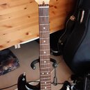 Elektrická kytara typu Stratocaster s korpusem v přechodové barvě od černé k hnědé a žluté. Má bílý pickguard, tři snímače a javorový krk s hmatníkem…
