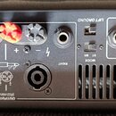 Zadní panel černého elektronického zařízení s řadou konektorů a přepínačů. Jsou zde nápisy INPUTS (kanály A a B), LIFT GROUND, MODE ST BR a OUTPUTS (…