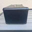 Černý kytarový kombozesilovač s povrchem z texturovaného vinylu. Na horní straně je umístena kovová rukojeť a dekorativní kovový pásek. Rohy jsou chr…
