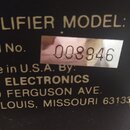 Detail štítku na černém povrchu s bílým textem. Je zde uveden nápis AMPLIFIER MODEL: CR- a Serial No. s přilepenou nálepkou, na které je číslo 008946…