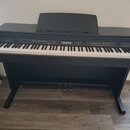Černý digitální piano s klaviaturou a integrovaným stojanem. Na levé straně ovládacího panelu je nápis MEDELI a na pravé straně označení DP330. Nástr…