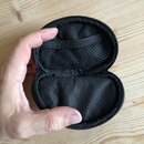 Otevřené černé pouzdro z textního materiálu s zipem. V horní části je všívaná síťovaná kapsa s elastickou stahovací šňůrkou. Na povrchu nejsou žádné…