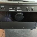 Zadní strana černého komba s povrchem z imitace kůže. Na horním panelu jsou konektory LINE IN a LINE OUT, GROUND, napájecí vstup s nápisem 230V~50Hz…