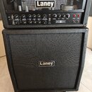 Černý kytarový kombozesilovač složený z hlavy a boxu. Na horním panelu hlavy je logo Laney a nápis IRONHEART, dále jsou zde ovládací prvky s popisky…