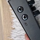 Černý kovový efekt pedál s matným povrchem. Na boční straně jsou dva jack konektory a jeden USB port. V horní části jsou vidět tři černé oválné ovlád…