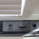 Detail zadní strany černého elektronického zařízení s konektory. Jsou zde nápisy DC9V 300mA u napájecího vstupu, MANUAL(SW) nad přepínačem a VOLUME(P…