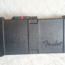 Černý tvrdý kufýr z plastu s rukojetí a zámky. Na pravé straně je vyražené logo Fender®. Povrch vykazuje lehké známky používání v podobě drobných škr…