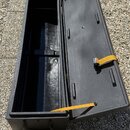 Otevřený černý tvrdý kufýr pravděpodobně určený pro klavír nebo keyboard. Vnitřní prostor je prázdný a černý, víko je vybaveno třemi žlutými popruhy…