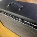 Černý kytarový kombozesilovač s texturovaným povrchem a šedou přední síťovkou. Na čelním panelu je nápis SUPER-SONIC™ a pod ním text FENDER MUSICAL I…