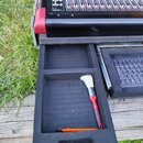 Fotografie zachycuje část digitální mixážní konzole s nápisem DiGiCo G. V otevřeném spodním přihrádce z černého pěnového materiálu leží štětec s červ…