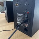 Zadní strana černého studiového monitoru značky SAMSON s označením MEDIAONE BT4 a nápisem ACTIVE STUDIO MONITORS WITH BLUETOOTH. V horní části jsou v…