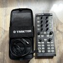 Černý DJ kontrolér s nápisy TRAKTOR a KONTROL X1. Zařízení obsahuje několik otočných knoflíků, tlačítek a posuvníků s různými popisky, jako například…