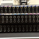 Tři černé rackové patchpanely s řadou 24 jackových vstupů, které jsou číslovány od 1 do 24. Horní panel obsahuje nad a pod konektory bílé papírové št…