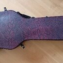 Tvrdyz kývný kufýr na kytaru v tmavě červené barvě s texturovaným povrchem. Na spodní části je červený nápis Gibson USA. Kufýr má černé úchyty a kovo…