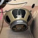 Fotografie zachycuje reproduktor v dřevěné skříni. Na zadním krytu je nápis CELESTION LOUDSPEAKERS, G12 G12 a Vintage 30. Na horní části rámu je bílá…