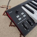 Černá MIDI klaviatura s bílými a černými klávesami. Na ovládacím panelu je nápis iCON, označení modelu i-KEYBOARD NANO a tlačítka s popisky Trans < >…