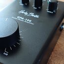 Černý kytarový koncové stupně s kovovým šasi. Na horním panelu je bílý nápis „Harley Benton“, modelové označení „GPA-100“ a text „Guitar Power Amplif…
