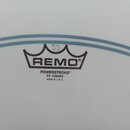 Detail bílého, matného bubenového koženu s modrými vodorovnými pruhy. Uprostřed je černý nápis REMO pod symbolem koruny a text POWERSTROKE® P3 COATED…