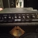 Černý basový zesilovač s nápisem Hartke uprostřed spodní lišty. Vlevo dole je text LX5000 BASS AMPLIFIER a vpravo dole CLASS A TUBE PREAMP. Přední pa…