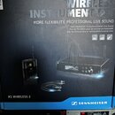 Fotografie zachycuje krabici a část obsahu bezdrátového systému. Na krabici je nápis WIRELESS INSTRUMENT SET, slogan MORE FLEXIBILITY, PROFESSIONAL L…