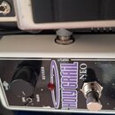 Bílý efekt pedál s černým ovládacím panelem. Na panelu je nápis HOLY GRAIL NEO a logo electro-harmonix. Obsahuje jeden černý otočný knoflík, přepínač…