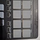 Detailní pohled na ovládací panel černého MIDI kontroléru s bílými podsvícenými pady. Na pravé straně je svisle napsáno nanokEY Studio MOBILE MIDI KE…