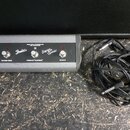 Šedý plastový ovladač s třemi přepínači a dvěma červenými kontrolkami. Na přední straně jsou nápisy Fender, Super Sonic a popisky přepínačů VINTAGE/B…