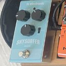 Světle modrý efekt pedál s nápisy tc electronic a SKY SURFER REVERB. Na horní části jsou dva ovládací knoflíky s popisky REVERB a MIX, uprostřed jede…