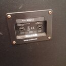 Fotografie zachycuje zadní panel reproduktoru s kovovým rámem a třemi vstupy. Na panelu jsou nápisy MODEL: MC212, made by Marshall Amplification plc…