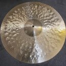 Kruhový mosazný činel s výrazným kovaným povrchem a koncentrickými rýhami. Na horní části je kurzivním písmem nápis Paiste a ve spodní části text Dry…