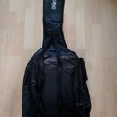 Černý textilní obal na hudební nástroj s ramenními popruhy a boční kapsou. Na horní části je bílý nápis ROCK BAG a pod ním menší text by HARLEY BENTO…