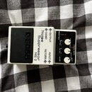 Bílý efekt pedál s černým stupňovitým šlapadlem. Na těle jsou nápisy BOSS, Noise Suppressor NS-2 a označení konektorů OUTPUT, SEND, RETURN, INPUT. Ov…