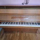 Dřevěný digitální piano v hnědé barvě s klávesnicí. Na předním panelu nad klávesami je umístěno logo „Rösler“. Nástroj vykazuje známky běžného použív…