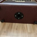 Hnědý kytarový kombozesilovač s povrchem z texturovaného vinylu. Na předním černém textilním krytu je bílo-zlaté logo Marshall. Horní ovládací panel…