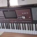 Černý digitální klavír s nápisy KORG a Pa700 PROFESSIONAL ARRANGER. Nástroj má v horní části displej, ovládací tlačítka atočítko, vpravo je umístěn r…