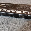 Černý rackový procesor s nápisem ULTRAFEX II, THE MULTIBAND SOUND ENHANCEMENT PROCESSOR MODEL EX 3100. Zařízení má na zadní straně čtyři konektory ty…