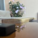 Detailní pohled na hmatník a krk strunného nástroje z lehkého dřeva. Povrch dřeva v místě spoje s korpusem vykazuje známky opotřebení a mírné znečišt…