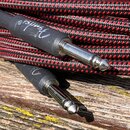 Černý instrumentální kabel s červeně a černě pleteným oplatením. Na černém plastovém krytu konektoru je bílý nápis Fender®. Kovové konektory jsou v č…