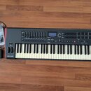 Černý MIDI kontrolér s klávesnicí a červeným bočním panelem. Na přístroji jsou nápisy novation, IMPULSE a v pravé části označení Pad Mode, Note Mode…