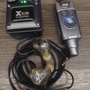 Na fotografii je černý přijímač s nápisem Xvive U4 RECEIVER, dva ovládací knoflíky a zelené kontrolní LED diody. Vedle něj je stříbrný bezdrátový vys…