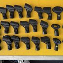 Na žlutém povrchu je rozloženo 24 kusů černých ladicích kolíků z plastu. Kolíky mají různé tvary, přičemž většina z nich je v ergonomickém zakaleném…