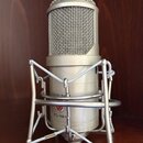 Stříbrný kondenzátorový mikrofon v pavoucím držáku. Na těle mikrofonu jsou nápisy LAUTEN AUDIO a FC-357. Povrch je v dobrém stavu bez viditelného opo…